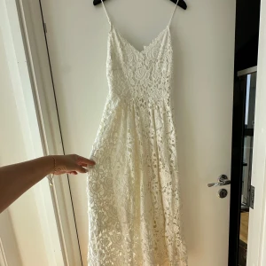 Klänning  - Letar du efter det ultimata statement-plagget för ditt nästa evenemang? Sök inte längre! Vår ärmlösa, rygglösa festklänning utstrålar elegans och sofistikering. Med sin eleganta design och smickrande silhuett är denna klänning perfekt för att göra en