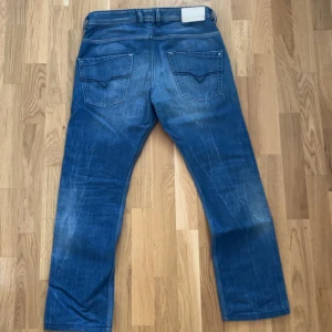 Blå jeans från Diesel - Säljer ett par snygga blå jeans från Diesel med en klassisk femficksdesign. Jeansen har en lätt tvättad look och en knappgylf. Perfekta för en avslappnad stil.