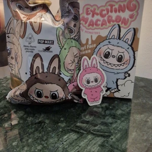 Labubu Exciting Macaron - Popmart - Säljer en äkta öppnad box Labubu men oöppnad påse. Det är den som är på bilden i påsen. Har bara öppnat undersidan på kartongen kommer tejpa med dubbelhäftande tejp så att man får samma känsla när man köper en Blindbox  Kvitto finns