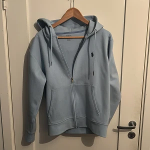 Ljusblå Ralph Lauren zip  - Säljer en riktigt schysst Ralph lauren zip som är i utmärkt skick. Endast använd 2 gånger. 
