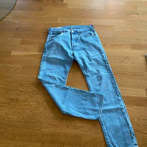Levis 501 jeans i ljusblå denim - Säljer ett par klassiska Levis 501 jeans i ljusblå denim. De har en rak passform och är tillverkade i bomull. Perfekta för en avslappnad stil.