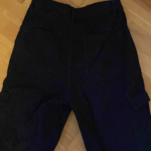 Svarta wide leg byxor från Don't Call Me Jennifer - Snygga svarta wide leg cargo jeans från Don't Call Me Jennifer. De har en knapp och dragkedja framtill och praktiska fickor på sidorna. Perfekta för en stilren look.🖤🥀