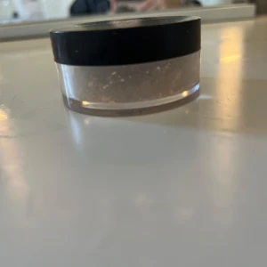 Transparent puder från HEYXI - Säljer ett transparent puder från HEYXI. Perfekt för att sätta sminket och ge en matt finish. Kommer i en praktisk burk med svart lock. Lätt att ta med i väskan för touch-ups under dagen.