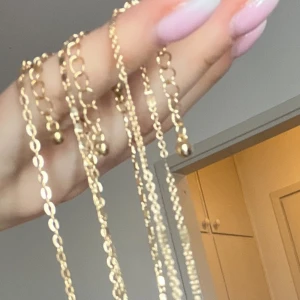 Guldarmband med kedjedesign - Säljer eleganta guldarmband med kedjedesign. Perfekta för att lägga till en touch av stil till din outfit. Armbanden har en justerbar längd och en fin glans som fångar ljuset vackert.