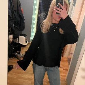 Svart stickad tröja med långa ärmar - Säljer en stilren svart tröja med långa ärmar. Perfekt för en avslappnad look. Tröjan har en enkel design och är lätt att matcha med olika outfits.