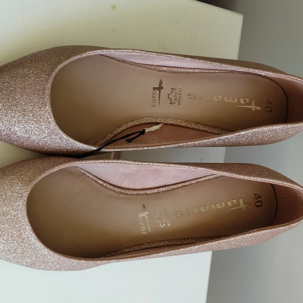Snygga glittriga pumps från Tamaris i en elegant rosa nyans. Skorna har en spetsig tå och en bekväm klack som ger en stilren look. Perfekta för att sätta lite extra glans på din outfit.. Kengät.