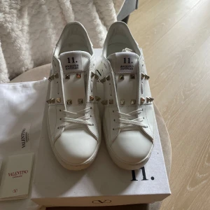 Vita sneakers från Valentino - Snygga vita sneakers från Valentino, Garavani. Endast använda 2 gånger, tillkommer låda och dustbags till skorna. Köpte dem för ungefär 8000kr och säljer dem för de inte kommer till någon användning.💞💞
