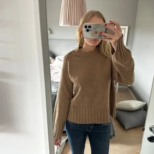 Beige stickad tröja - Säljer en mysig beige stickad tröja med långa ärmar och ribbade detaljer vid ärmslut och nederkant. Perfekt för kyligare dagar och enkel att matcha med jeans eller kjol. Hör av dig vid intresse!