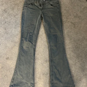 Grå randiga bootcut jeans - Snygga grå bootcut jeans med ränder. De har en lågmidjad passform. 