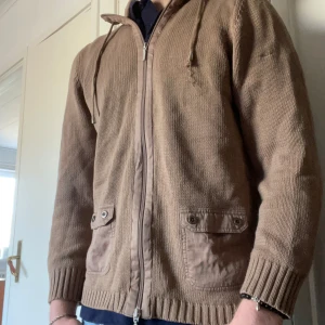 Brun stickad hoodie från Atelier AG Création - Säljer en brun stickad kofta från Atelier AG Création. Storlek S, passar mig perfekt och är 185. Koftan är i ett väldigt fint skick. Bara att höra av sig om det finns funderingar🤩