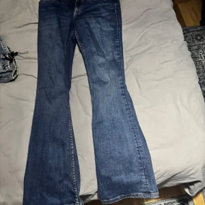 Blå bootcut jeans - Snygga blå bootcut jeans med klassisk femficksdesign. Perfekta för en avslappnad stil med en touch av retro. De har en bekväm passform och är tillverkade i ett slitstarkt denimtyg.