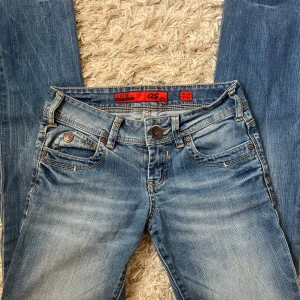 Blå jeans från QS by S.Oliver - Snygga blå jeans från QS by S.Oliver med en klassisk femficksdesign och subtila slitningar. De har en låg midja och en bootcut-stil som ger en avslappnad look.❤️❤️