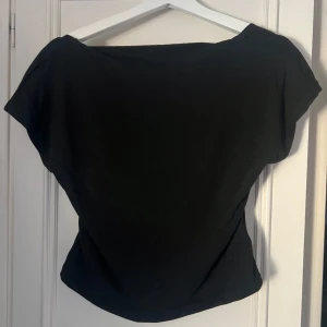 Svart topp från Shein - Snygg svart topp från Shein med en öppen rygg och korta ärmar. Perfekt för en stilren look. Tillverkad i ett mjukt och bekvämt material.