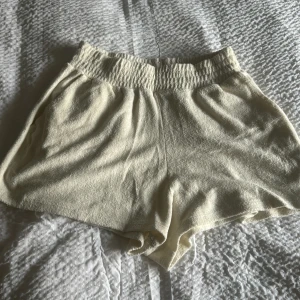 Beige frottéshorts - Säljer ett par bekväma beige shorts i frotté. De har en elastisk midja för en skön passform och är perfekta för avslappnade dagar. Passar bra till sommarens varma väder.