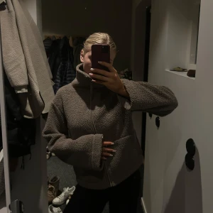 Teddyjacka H&M - Mysig brun teddyjacka med dragkedja framtill. Perfekt för kyliga dagar med sin fluffiga och varma design. Jackan är använd men i mycket bra skick. Hör av er vid frågor och funderingar!🤎