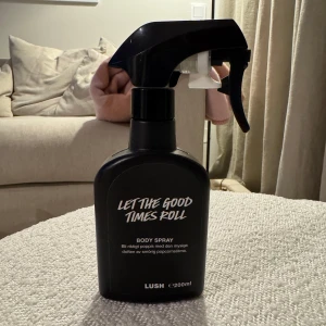 Let The Good Times Roll Body Spray från Lush - Säljer en flaska Let The Good Times Roll Body Spray från Lush. Den har en magisk doft av söt och kryddig pepparkaka. Flaskan är svart med vit text och rymmer 200 ml. Perfekt för att fräscha upp din dag med en härlig doft. Helt ny och oanvänd. 