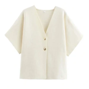 Vit kortärmad kofta med knappar - Snygg vit kofta med korta ärmar och två knappar framtill. Perfekt för en enkel outfit. Passar bra till både jeans och kjol.