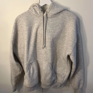 Grå hoodie från BikBok - Säljer en mysig grå hoodie från BikBok i storlek S. Den har en klassisk design med känguruficka och justerbar huva. Hör av dig vid intresse!