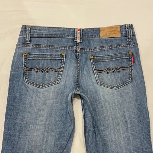 Lågmidjade bootcut jeans med snygga detaljer🤩 - Midja 40x2 cm, gren 19,5 cm o innerben 75 cm💕korta på mig som är 169 o xs-s. Märkta W28 men sitter som en S-stor xs