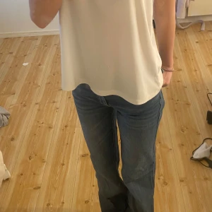 Blå jeans med knappar - Snygga blå jeans med en klassisk design och knappar på bakfickorna. De har en rak passform och är perfekta för en avslappnad stil. Jeansen har en normal midja och är tillverkade i ett slitstarkt material.