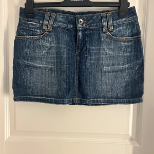 Lågmidjad jeans kjol!!! - Snygg jeanskjol från Only i klassisk blå denim. Kjolen har en kort längd med femficksdesign och bälteshällor. Perfekt för en avslappnad stil med en touch av retro. Den har en knapp och dragkedja framtill för enkel påklädning.
