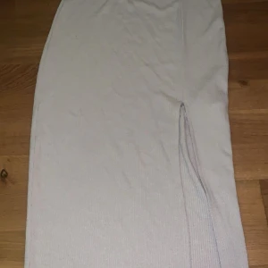 Beige kjol - Beige lång kjol med en medel hög slit på sidan. Kjolen är ifrån bikbok i storleken 36(S)