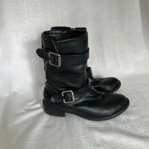 Svarta boots - Sjukt snygga svarta boots / kängor med spännen. Storlek 39, passar även 38. Fotsula mått: ca 25 cm. Klack: 3 cm 🖤