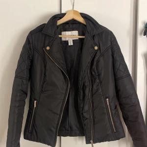 Svart quiltad jacka med dragkedja - Säljer en snygg svart jacka från NLY TREND i storlek XS/34. Jackan har en cool bikerstil med quiltade detaljer på axlarna och ärmarna. Den har en asymmetrisk dragkedja och två fickor med dragkedjor. Perfekt för höst och vår! Vid frågor är det bara att skriva!💓