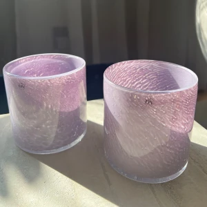 Lila glasljuslyktor - Två vackra lila glasljuslyktor. Perfekta för att skapa en mysig stämning i hemmet. De har en rund form och en mjuk lila färg som ger ett elegant intryck. Passar utmärkt som dekoration eller för att lysa upp mörka kvällar. 💜🌟