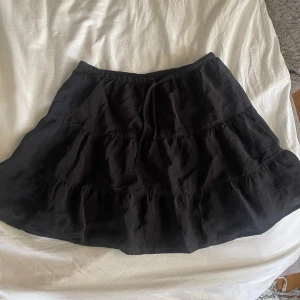 Volangkjol  - Svart volangkjol från H&M  Aldrig använd, storlek XS Har resårband framtill så lätt att justera om man vill den ska sitta tightare