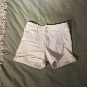 Vita shorts - Säljer ett par vita shorts i bomull. De har en klassisk design med fickor både fram och bak. Perfekta för sommardagar! 🏖️Dom har tyvär en liten gräs föäck därbak💗