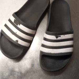 Svarta och vita sandaler från Adidas - Säljer dessa svarta tofflor från Adidas. 🖤