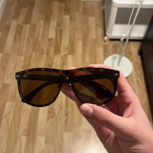 Solglasögon från Ray-Ban - Snygga solglasögon från Ray-Ban med en klassisk design. Bågarna har ett leopardmönster i bruna nyanser och glasen är mörka. Perfekta för soliga dagar och kommer med ett stilrent fodral.
