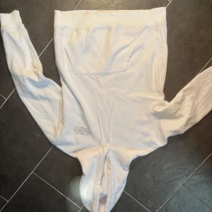 Vit Star Wars hoodie - Säljer en vit H&M hoodie med Star Wars-tryck. Tröjan har en stor ficka framtill och en justerbar huva med snören. Perfekt för alla Star Wars-fans som vill ha en bekväm och stilren look.