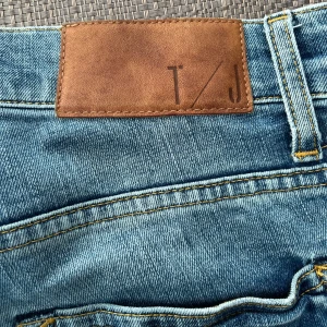 Ljusblå jeans från Tiger of Sweden - Snygga ljusblå jeans från Tiger of Sweden med klassisk femficksdesign. Perfekta för en avslappnad stil med en modern touch. Märkesdetaljer på baksidan ger en exklusiv känsla. Des storlek är 28/32 och model, Pistolero