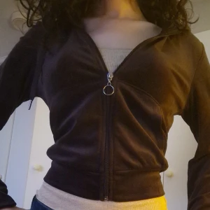 Brun hoodie från Gina Tricot - Säljer en snygg brun hoodie från Gina Tricot i storlek XS. Den har dragkedja framtill och en praktisk huva med snören. Perfekt för en avslappnad stil. Helt oanvänd. Köpt för ungefär 300-400kr. Pris kan diskuteras