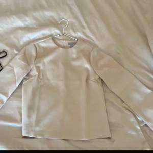 Elegant beige blus med långa ärmar och rund halsringning. Blusen har en diskret dragkedja i ryggen. Perfekt för en stilren look.