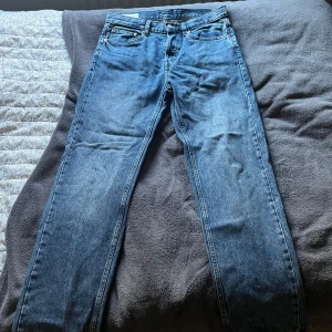 Blå jeans från Zara - Snygga blå jeans från Zara med klassisk femficksdesign och knappgylf. Perfekta för en avslappnad stil. Byxorna är helt nya