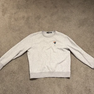 Grå sweatshirt från Ralph Lauren - Säljer en stilren och väldigt unik grå sweatshirt från Ralph Lauren med en broderad björn som spelar golf på bröstet. Tröjan är från Ralph Laurens golfkollektion och är i väldigt bra skick. Tröjan är strl L.
