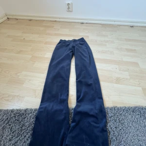 Mörkblå byxor från Gina Tricot - Snygga mörkblå byxor från Gina Tricot i en loose passform. Byxorna har en elastisk midja för extra komfort och är perfekta för en avslappnad stil. Tillverkade i ett mjukt material som känns skönt mot huden.