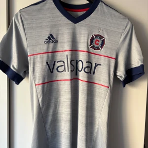 Signerad Chicago fire borta tröja 2018 - Detta är en fräck fotbolls tröja som man har haft sedan 2018! Tröjan är signerad av fotbollsspelaren Alexandar Katai! Tröjan är äkta och köpt borta i Chicago och är helt oskadad! 
