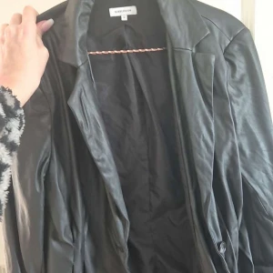 Svart skinnjacka från Bik Bok - Snygg svart skinnjacka från Bik Bok i storlek S. Jackan har en klassisk design med knappar framtill och långa ärmar. Perfekt för en stilren look.