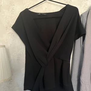 Svart Zara blus - En svart Zara blus med volang där fram, säljer eftersom jag inte fått någon andvändning av den på senaste. ❤️ skriv om ni har frågor eller vill ha fler bilder🥰