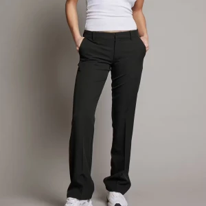 Svarta kostymbyxor från Bikbok st 36 - Snygga svarta kostymbyxor med en klassisk straight passform. Byxorna har en medel låg midja och är perfekta för en stilren look. De är tillverkade i ett bekvämt material och har diskreta fickor samt en dragkedja framtill. Dem är sparsamt använda men kan se lite slitna ut nedtill men det är inget jag märker av 😍st 36 skit snygga till en thight topp exempelvis