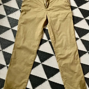 Olivgröna chinos - Snygga olivgröna chinos med normal passform och midwaist. Perfekta för en avslappnad stil. Tillverkade i ett bekvämt bomullsmaterial.