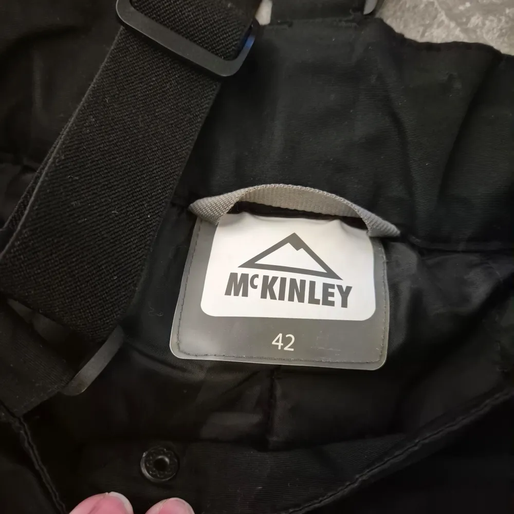Säljer ett par svarta täckbyxor från McKinley med justerbara hängslen och dragkedja. Perfekta för vinterns kalla dagar. Byxorna har en praktisk design med fickor och förstärkta knän. Några vita fläckar vid grenen men har ej testat ta bort det. . Farkut & Housut.