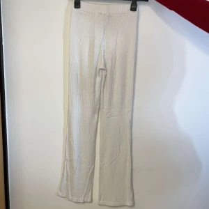 Vita ribbade byxor från Gina Tricot - Snygga vita ribbade byxor från Gina Tricot i storlek XS. Byxorna har en bekväm passform och är perfekta för en stilren look. De är tillverkade i ett mjukt material som ger en skön känsla hela dagen.