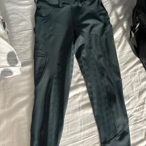 Svarta ridbyxor från Maya Delorez - Snygga gröna ridbyxor från Maya Delorez med hög midja och tight passform. Byxorna har praktiska fickor och en stilren design med diskreta mönsterdetaljer. Perfekta för ridning och ger en bekväm känsla i sadeln.  Säljer för 400kr, köpta för 1299kr. Knappt använda, som nya 😊