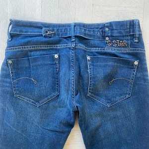 Blå jeans från G-Star - Jättesnygga och långa lågmidjade jeans från G-Star! Köpta på sellpy men säljer pga dom tyvärr inte passade mig! Står strlk 30 men skulle säga att dom är mindre än så. Innerbenslängd: 87cm, Midjemått: 40cm rakt över, Gren: 20cm