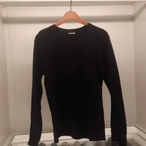 Svart långärmad tröja från Kappahl - Säljer en stilren svart långärmad tröja från Kappahl. Perfekt för en enkel och klassisk look. Tröjan är i en normal passform och tillverkad i ett bekvämt material.